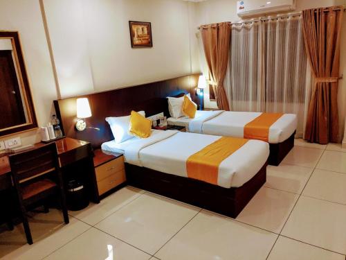 KottakkalHotel Virad的酒店客房配有两张床和一张书桌