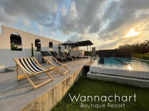 Tha Sala万纳察尔特精品度假酒店的一个带躺椅的甲板和一个游泳池