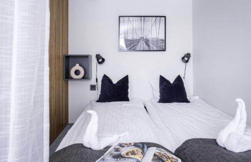 耶尔费拉HOOM Home & Hotel Järfälla的一间卧室配有两张带黑色枕头的床和电视。