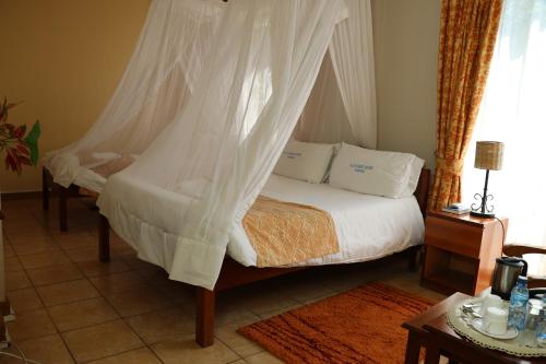 内罗毕ACK Guest House Nairobi的一间卧室配有一张带蚊帐的床
