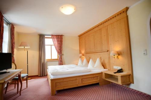 沙特瓦尔德爱鹏加斯霍夫祖尔波斯特宾馆的酒店客房,配有一张带木制床头板的床