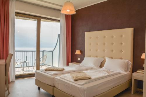 利莫内-苏尔加达HOTEL ASTOR的一间带大床的卧室和一个阳台