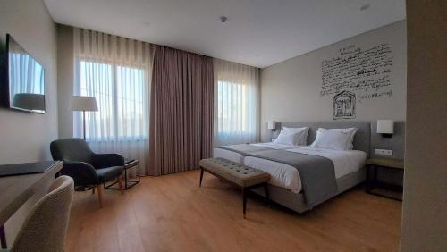维塞乌Casa da Torre - Viseu的酒店客房带一张大床和一把椅子