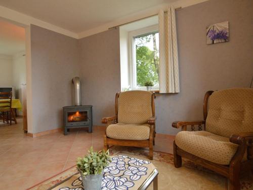 比特亨巴赫Holiday Home with Garden Heating Barbecue的客厅配有两把椅子和壁炉