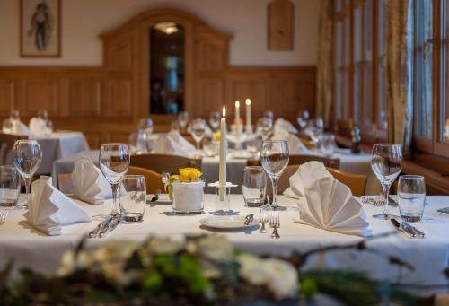 维尔德豪斯斯特木普斯艾尔鹏罗斯酒店的用餐室配有带玻璃杯和蜡烛的白色桌子