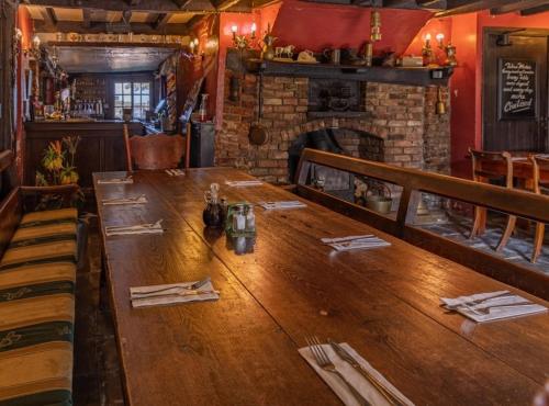 科宁斯比莱格特酒店的带壁炉的餐厅里一张长木桌