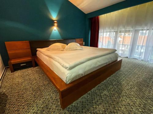 普洛耶什蒂贝斯特酒店的一间卧室设有一张蓝色墙壁的大床