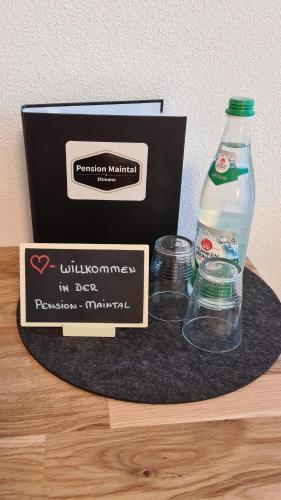 Eltmann美因塔尔艾尔特曼膳食酒店的一瓶水和一张桌子上的盒子