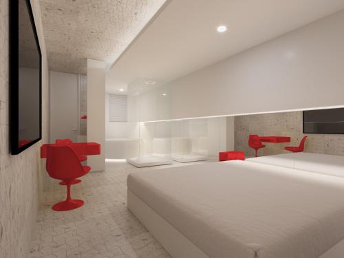 库里提巴Motel Você Que Sabe (Adult Only)的卧室配有白色大床和红色椅子