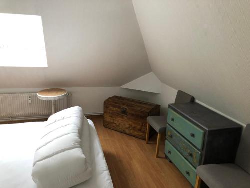 索姆河畔的圣瓦列里Chez Jules ,Parking gratuit, 3ème Etage的卧室配有白色的床和木制梳妆台。