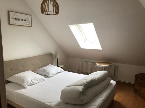 索姆河畔的圣瓦列里Chez Jules ,Parking gratuit, 3ème Etage的卧室配有一张白色大床和天窗