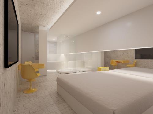库里提巴Motel Você Que Sabe (Adult Only)的白色卧室设有一张大床和一张黄色椅子