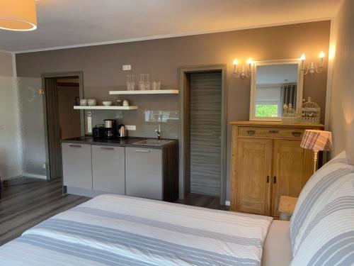 科赫姆魏恩堡菲伦豪斯旅馆的一间卧室配有一张床,厨房配有柜台