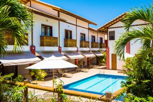 普拉亚多Apart Hotel Forte Blu的一个带游泳池和遮阳伞的酒店
