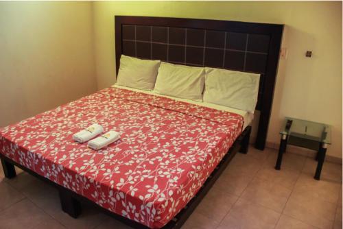特科曼Hotel Pacific的一间卧室配有一张大床和红色的床罩