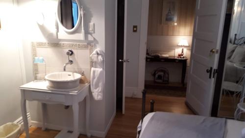 魁北克市特朗斯特住宿加早餐酒店的白色的浴室设有水槽和镜子