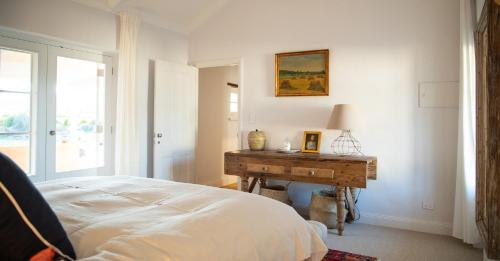 GreenockAlkina Old Quarter Luxury Accommodation的卧室配有一张床和一张书桌,毗邻窗户