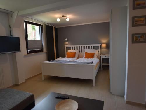 BlowatzApartment in Robertsdorf with Garden, Terrace, Barbecue的一间卧室配有带橙色枕头的床