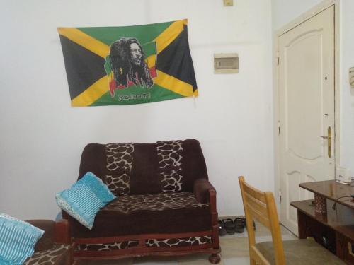赫尔格达Bob Marley Homestay的客厅配有沙发和墙上的旗帜
