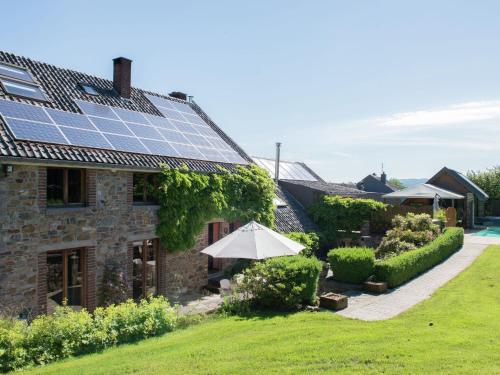 DesniéRuim vakantiehuis in Theux met een zwembad的屋顶上设有太阳能电池板的房子