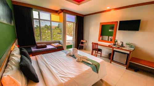Ban Pa Yang塔昌K2酒店的一间卧室配有一张床、一张书桌和一面镜子