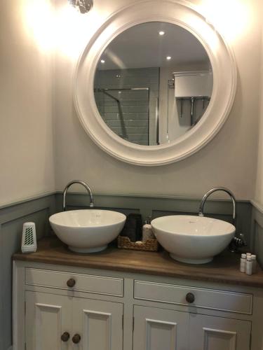 巴德利索尔特顿Herons Reach的一间带两个盥洗盆和大镜子的浴室