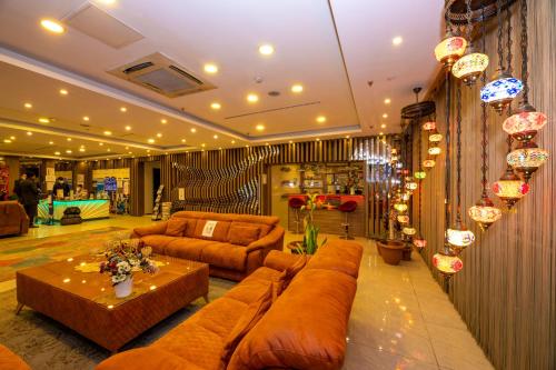 伊斯坦布尔嘉逸豪庭酒店的客厅配有棕色的沙发和桌子