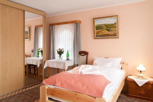 马兰迪瓦尔德海姆之家酒店的一间卧室配有一张床、一张桌子和一面镜子
