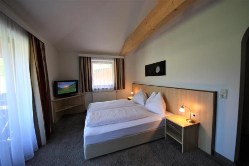 萨尔巴赫Hotel Sommerer - inklusive JOKER CARD im Sommer的酒店客房,配有床和电视