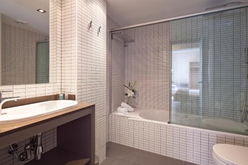 巴塞罗那Hotel Acta Laumon的带浴缸、盥洗盆和卫生间的浴室