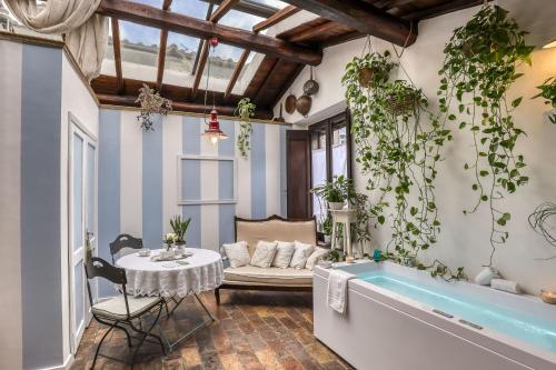 维泰博B&B dei Papi Boutique Hotel的客厅设有浴缸和植物桌子