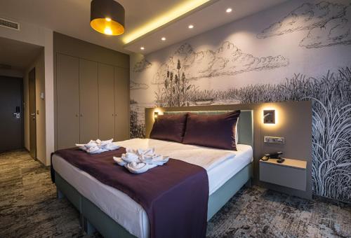 巴拉顿菲赖德Hotel Golden Lake Resort的一间卧室配有一张大床,上面放有两根蜡烛