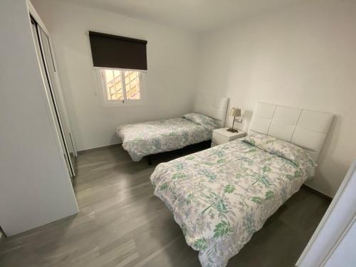 莫罗德哈布雷Jandia Suite的一间卧室设有两张床和窗户。