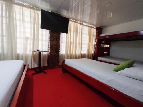 佛罗里达布兰卡Hotel Casablanca Cañaveral的一间卧室配有两张床,铺有红地毯