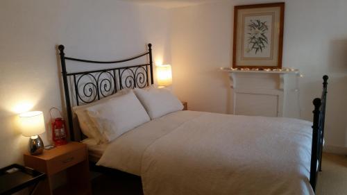 福伊Reed's of Fowey的一间卧室配有一张带两盏灯的大型白色床。