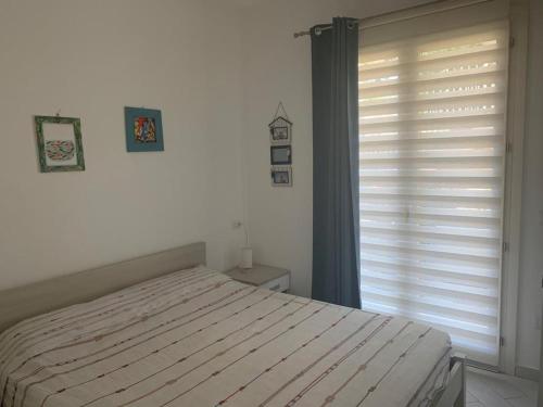 特里尼达古图Casa Moro的一间卧室配有一张床和一个带百叶窗的窗户