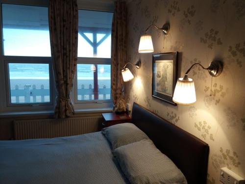 斯旺西比奇科默旅馆的卧室配有两盏灯,墙上设有一张床