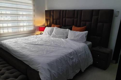 阿布贾Well furnished and spacious 2 bedroom apartment的一间卧室配有一张大床和大床头板