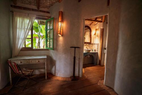 马劳Butterfly House Bahia的客房设有书桌、窗户和椅子。