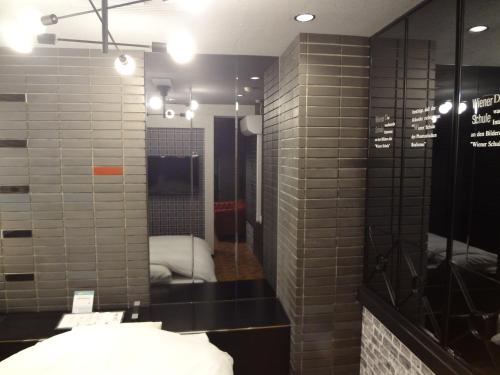 大垣Royal Hotel Uohachi Bettei的浴室设有灰色瓷砖墙壁和镜子