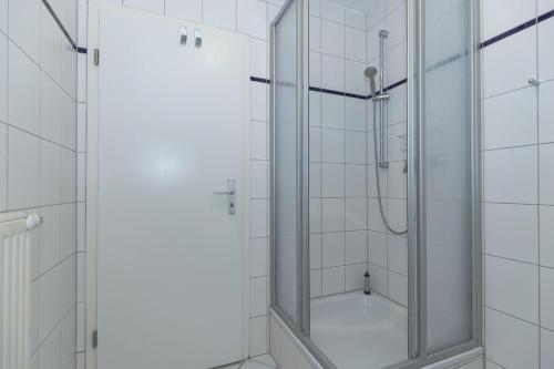奥斯赛拜-屈隆斯博恩Strandschloesschen-Haus-II-WE-20-9720的浴室里设有玻璃门淋浴