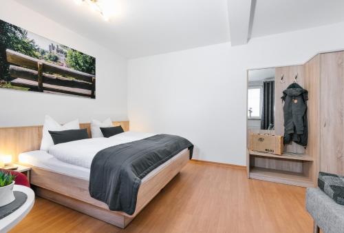 海尔巴德海利根斯塔特Am Landhof Heiligenstadt Ferienwohnung的一间卧室配有一张大床和一把椅子