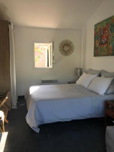 拉隆德莱丝莫里斯LA PASSIFLORE的卧室设有一张白色大床和一扇窗户。