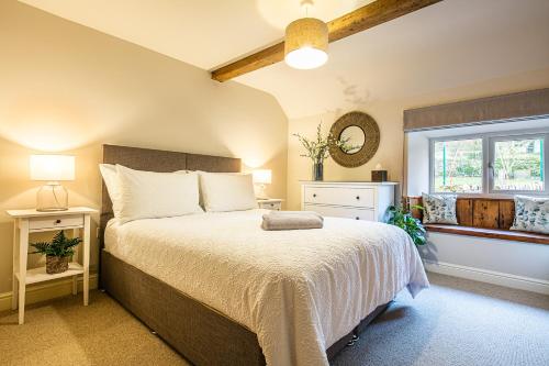ChelmortonJames Cottage的一间卧室设有一张大床和一个窗户。