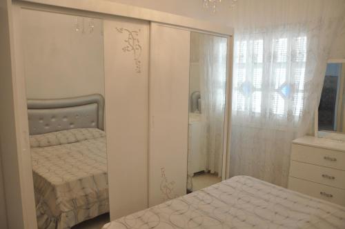 马赫迪耶Dar El Fatimid sur le port de Mahdia free WIFI的一间卧室配有一张床、梳妆台和镜子