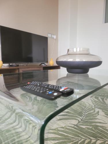 约翰内斯堡The Franklin Luxury Apartments, Unit 1604的电视的玻璃桌边的遥控器