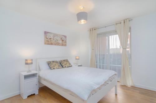 ThamesmeadKentmere Apartment Thamesmead的白色的卧室设有床和窗户