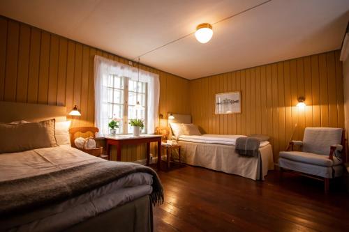 瓦斯泰纳Hotell Dahlströmska gården的酒店客房设有两张床和窗户。