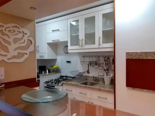 格拉玛多Resort com Natureza no Centro的厨房配有白色橱柜和炉灶烤箱。