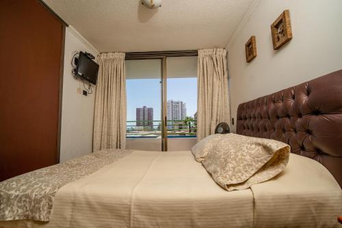伊基克阿波罗卡弯查公寓的一间卧室设有一张床和一个大窗户